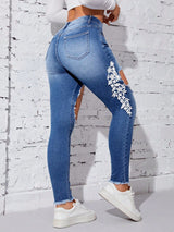 Jeans desgarro con bordado aplique floral